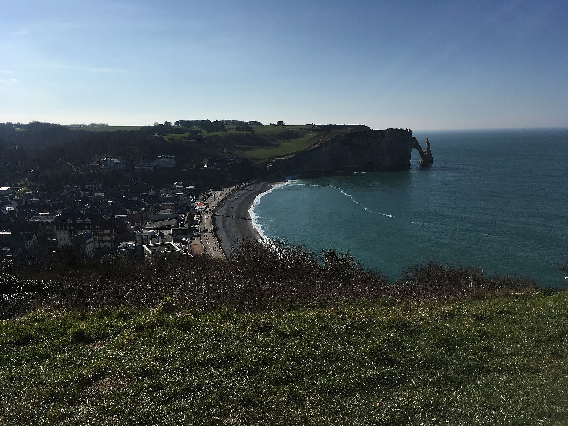 Mer vue depuis la falaise, étendue grise du large.